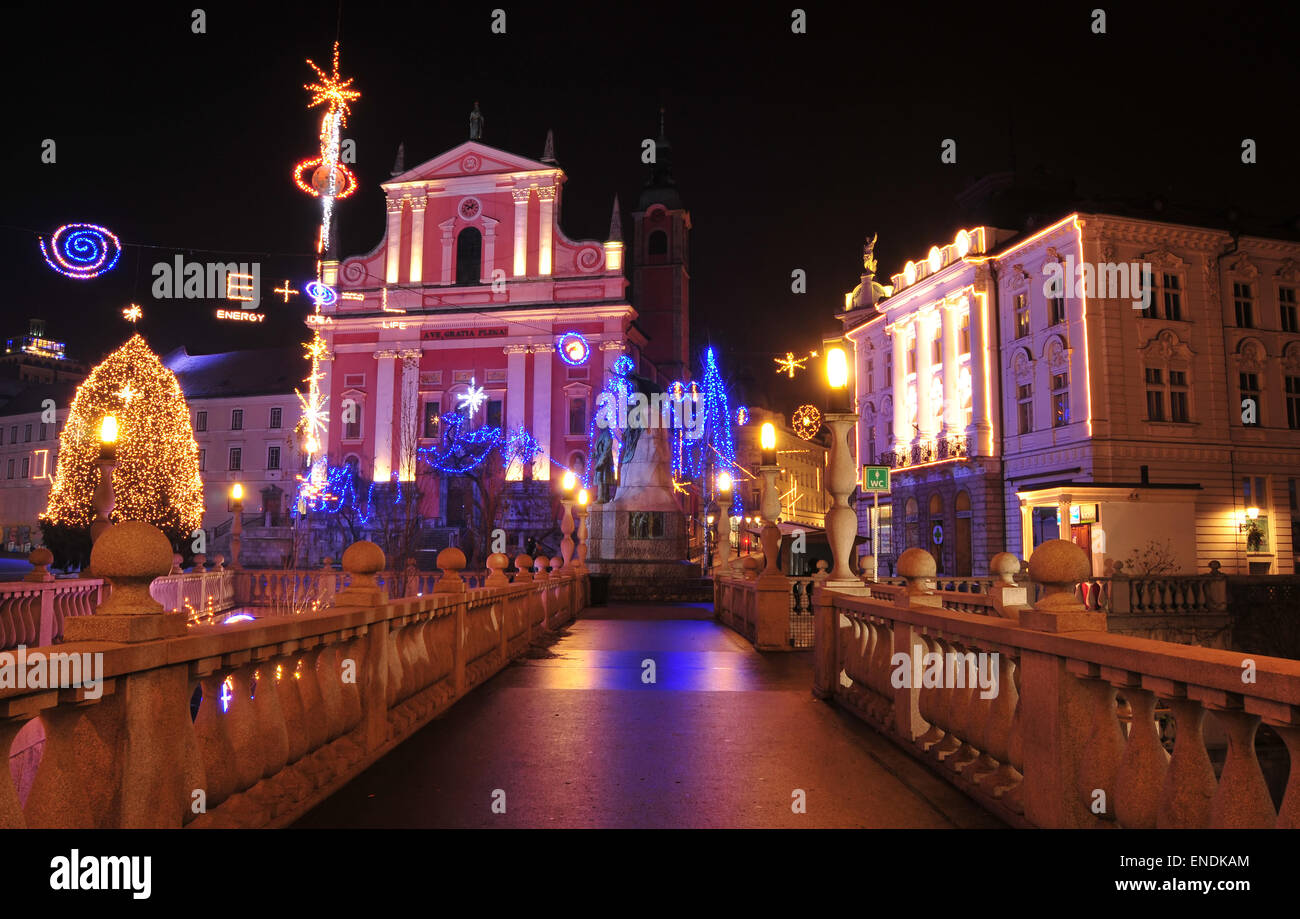 L'un des trois ponts Ljubljanas avec sainte église franciscaine à l'arrière-plan, décorée pour Noël et Nouvel An vacances Banque D'Images