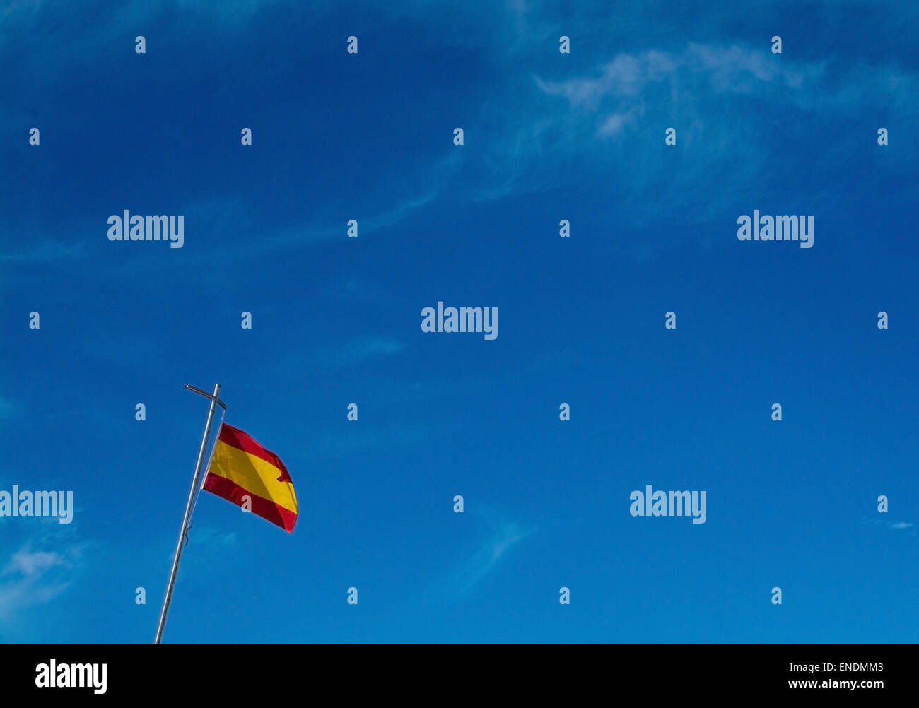 Drapeau espagnol contre le ciel bleu dans le coin inférieur gauche avec copie espace. Banque D'Images Drapeau espagnol contre le ciel bleu dans le coin inférieur gauche avec copie espace. Banque D'Images