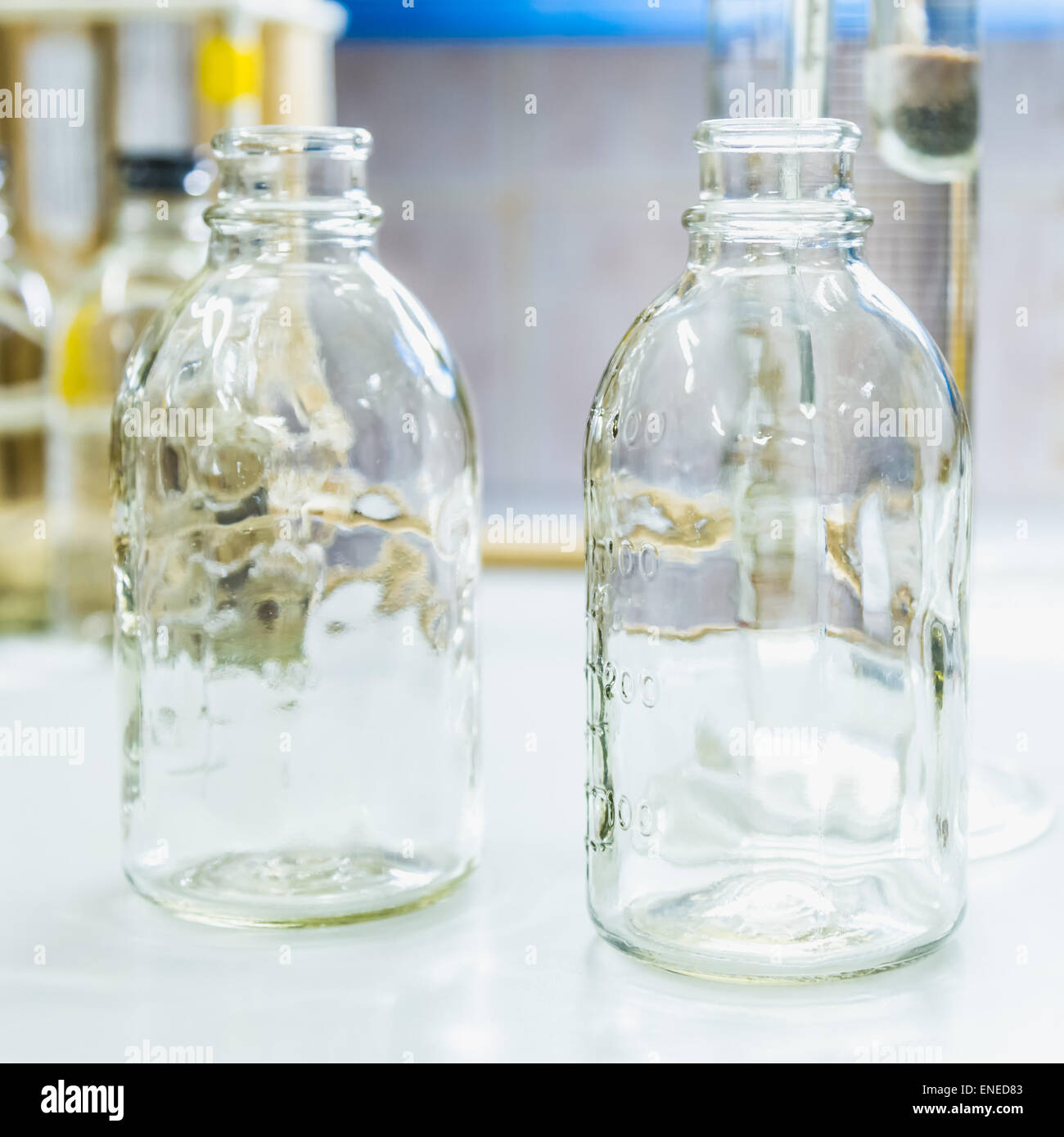 Bouteilles en verre vide sur la table. Verrerie de laboratoire de recherche Banque D'Images