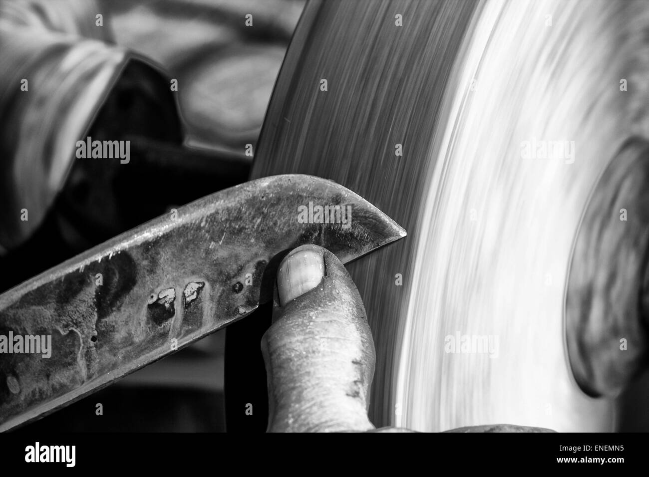 L'affûtage d'une lame sur une meule de grès humide Banque D'Images