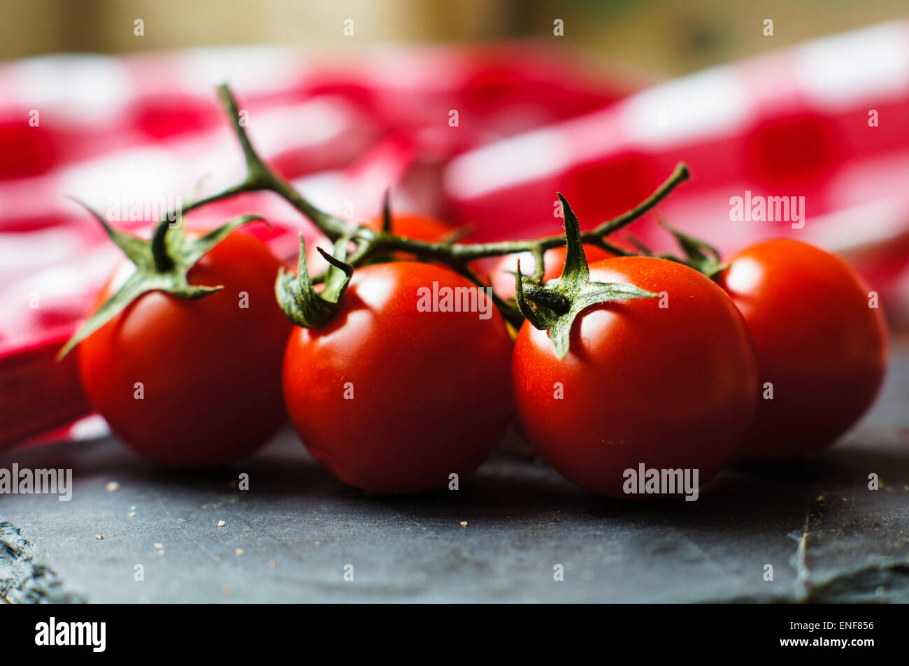 Bouquet de mûres fraîches tomates cerises rouges riches en antioxydants et vitamines sur la vigne sur un comptoir de cuisine gris foncé avec copysp Banque D'Images