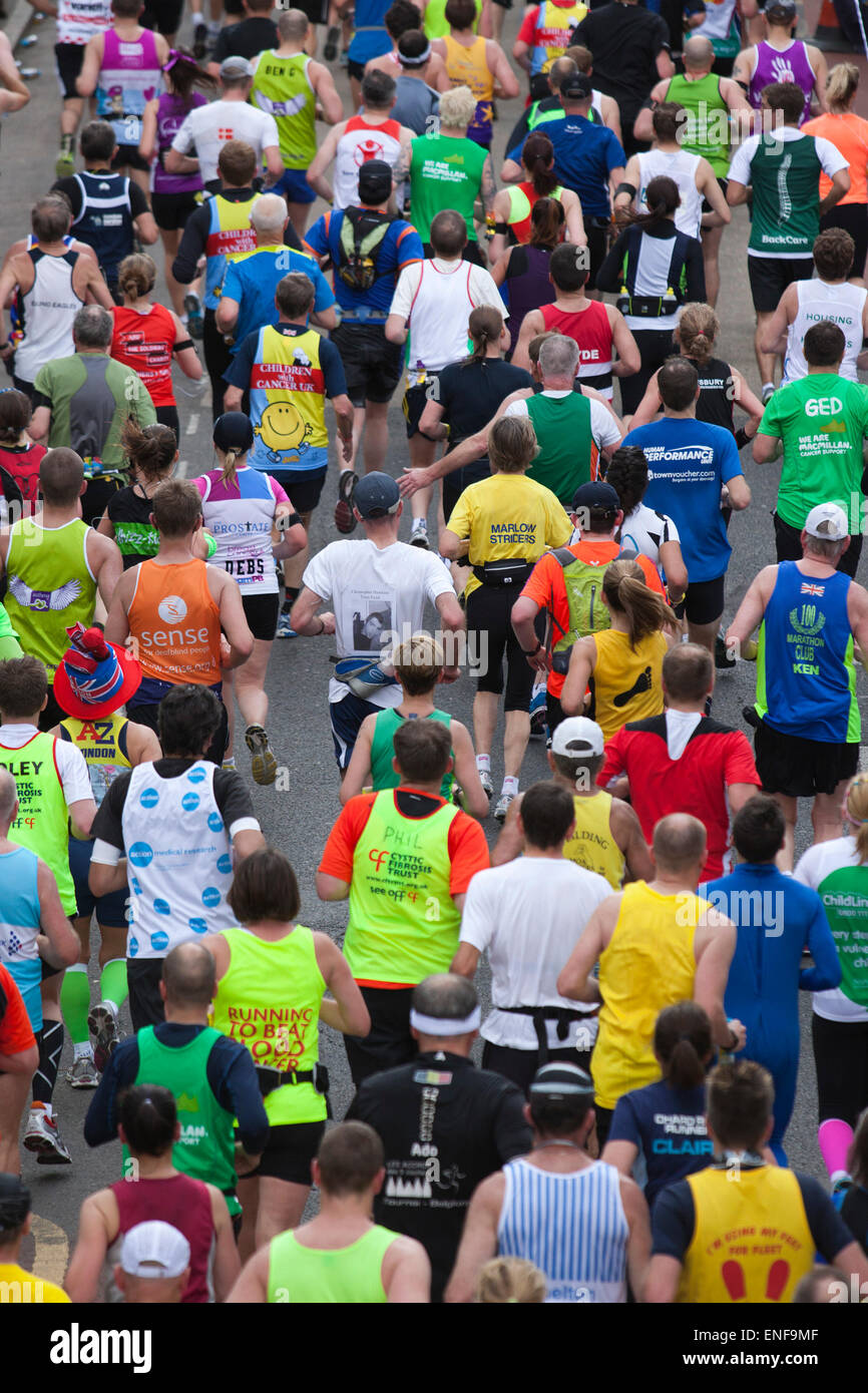 Champ principal, les coureurs prenant part aux organismes de bienfaisance et d'amusement. Les coureurs de marathon en route au point 15.5 miles dans les Docklands de Londres. Banque D'Images