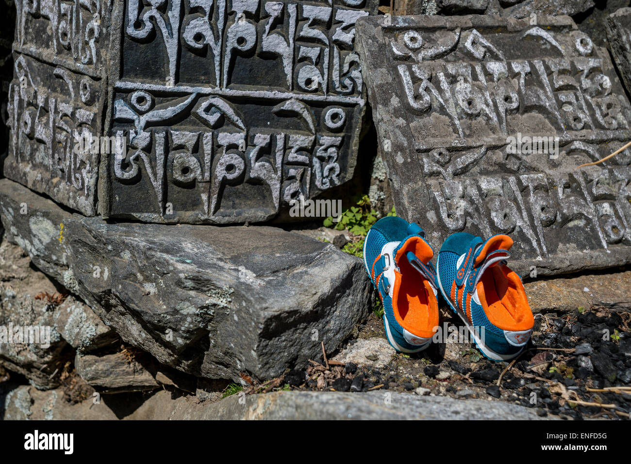 Pierres mani ancien et des chaussures de course, Népal Banque D'Images