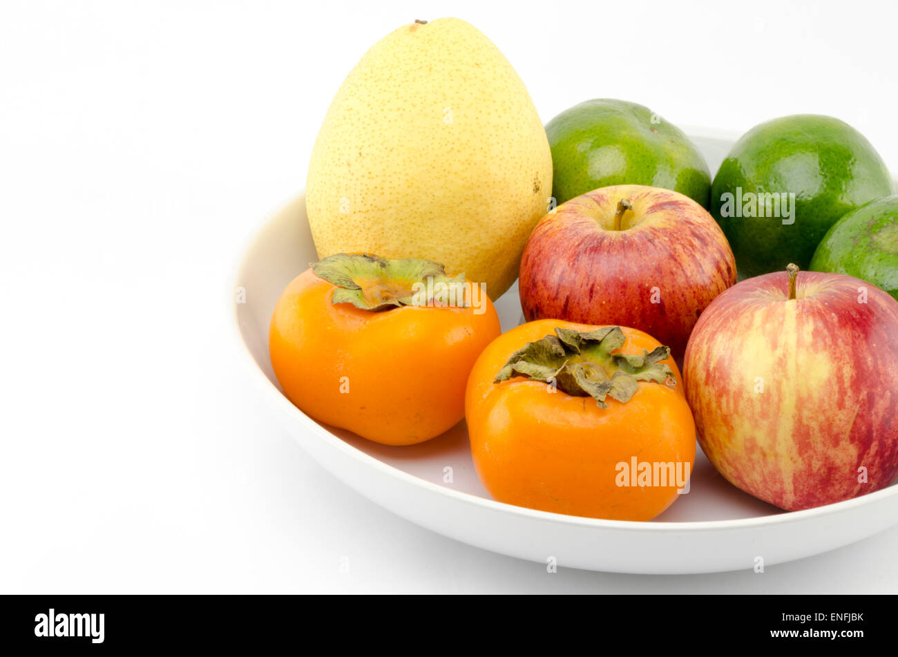 Poire chinois vert pomme et orange persimon sur plat blanc isolé sur fond blanc Banque D'Images