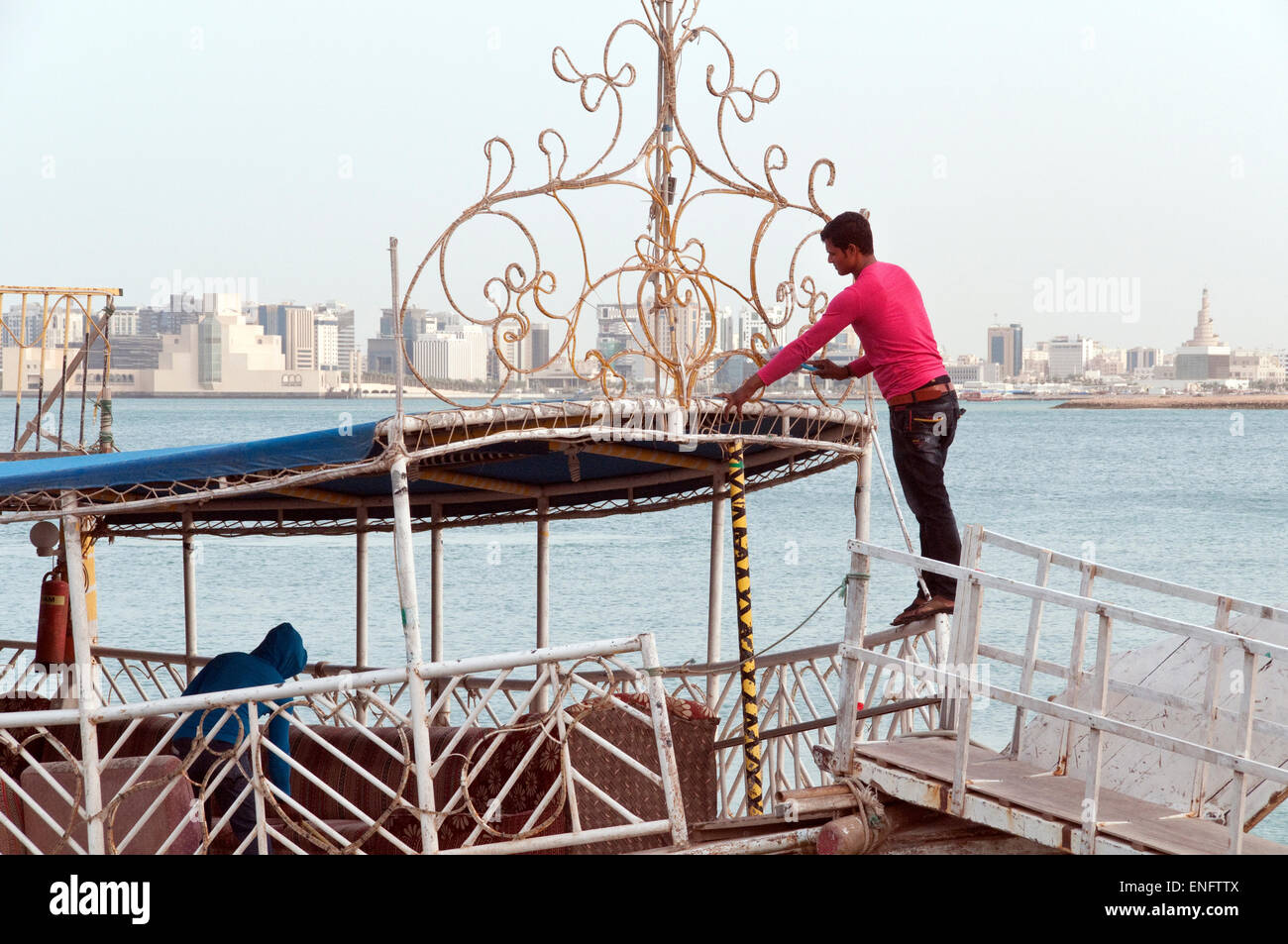 Les travailleurs sur un boutre touristiques préparer leur bateau amarré pour le départ à Doha, Qatar. Banque D'Images