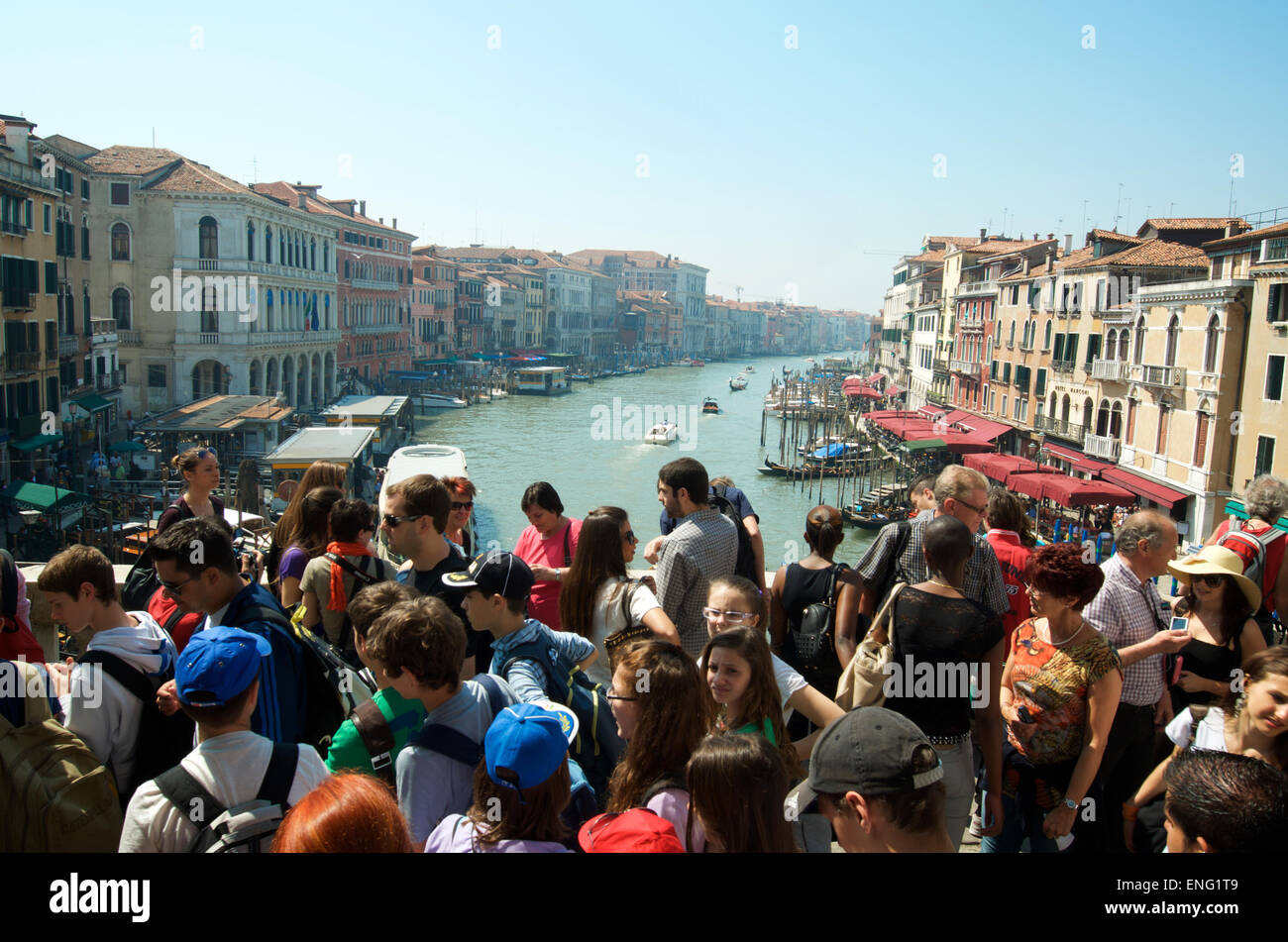 Venise, Italie - 24 avril 2013 : des foules de touristes passent le long du pont du Rialto à l'encontre d'une vue sur le Grand Canal. Banque D'Images
