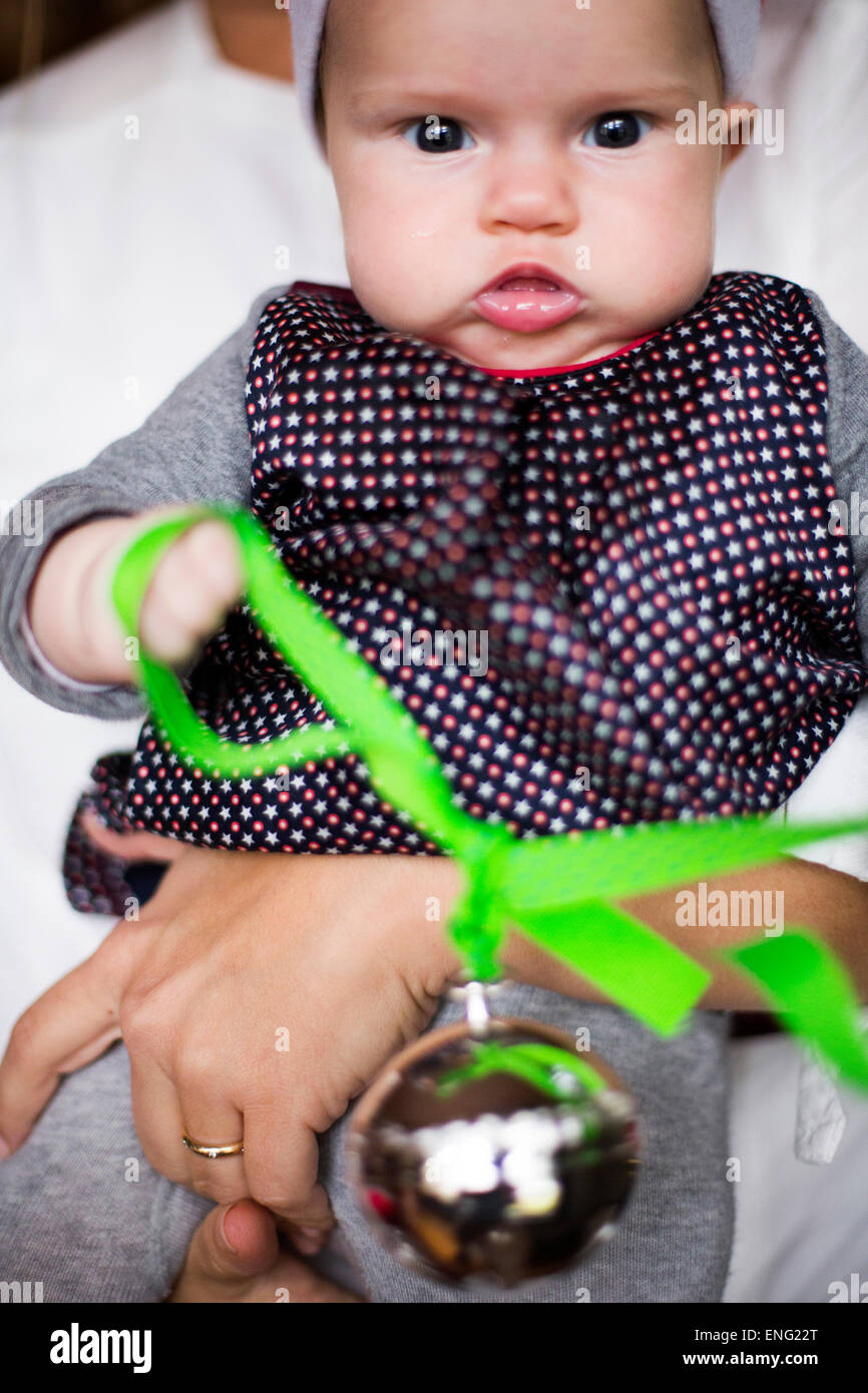 Close up of Caucasian baby girl holding Christmas ornament Banque D'Images