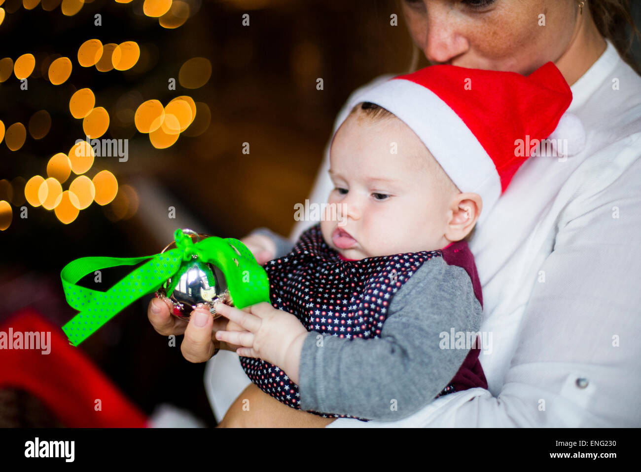 Close up of mother holding baby girl with Christmas ornament Banque D'Images