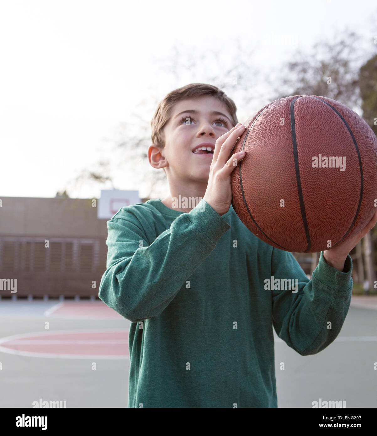 Caucasian boy holding basketball on court Banque D'Images