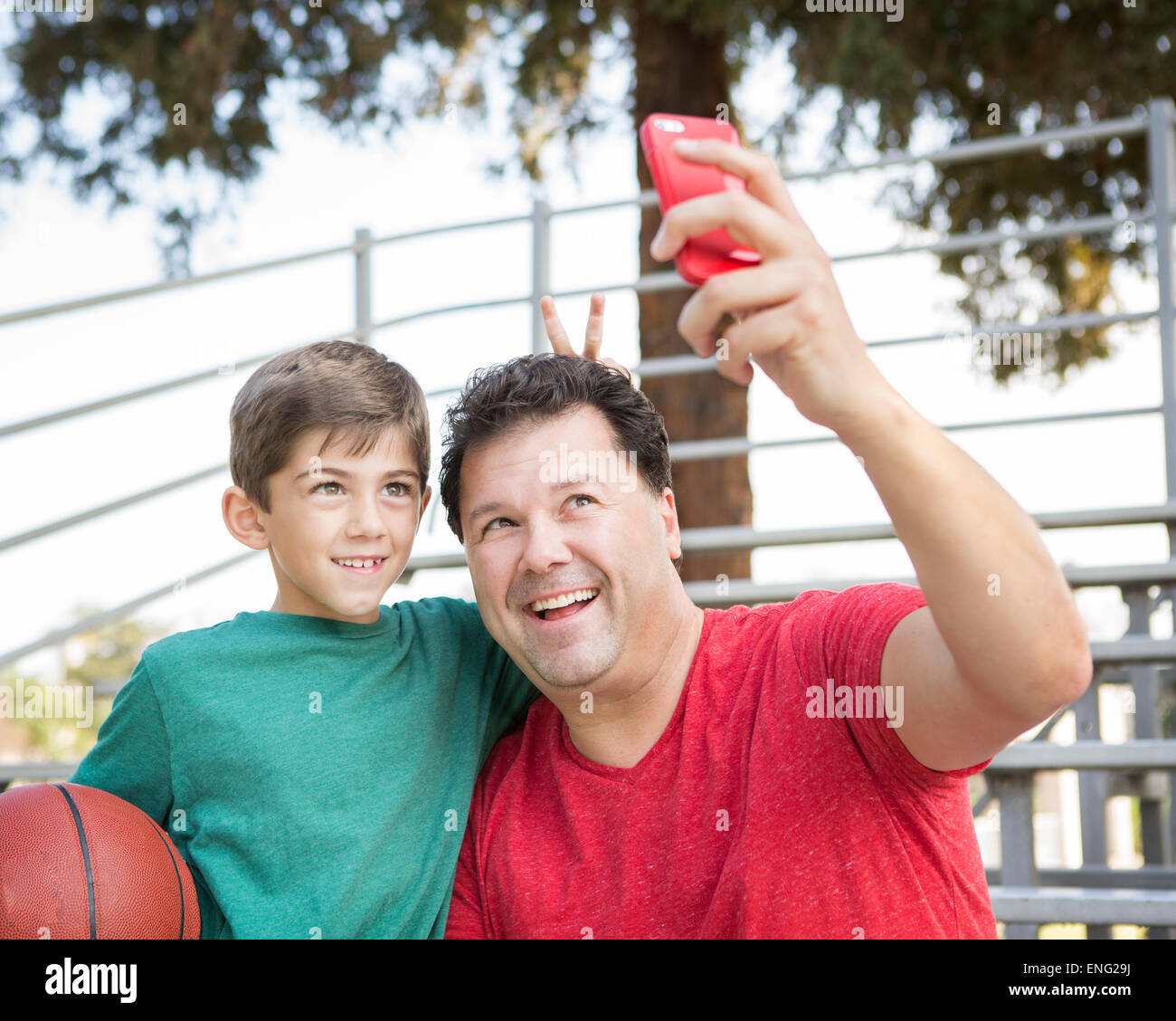 Portrait père et fils prenant cell phone photo sur des gradins Banque D'Images
