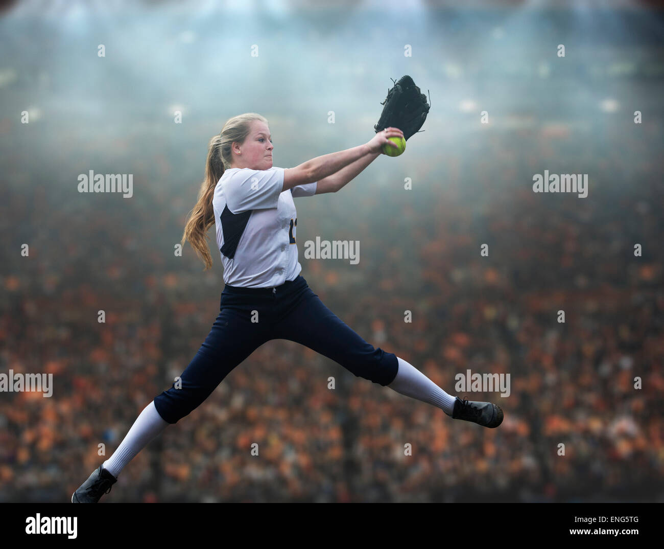 Pitching softball ball caucasienne dans stadium Banque D'Images