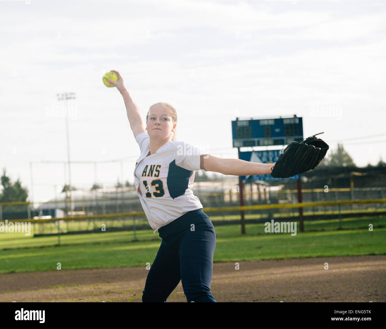Pitching softball caucasienne ball in field Banque D'Images