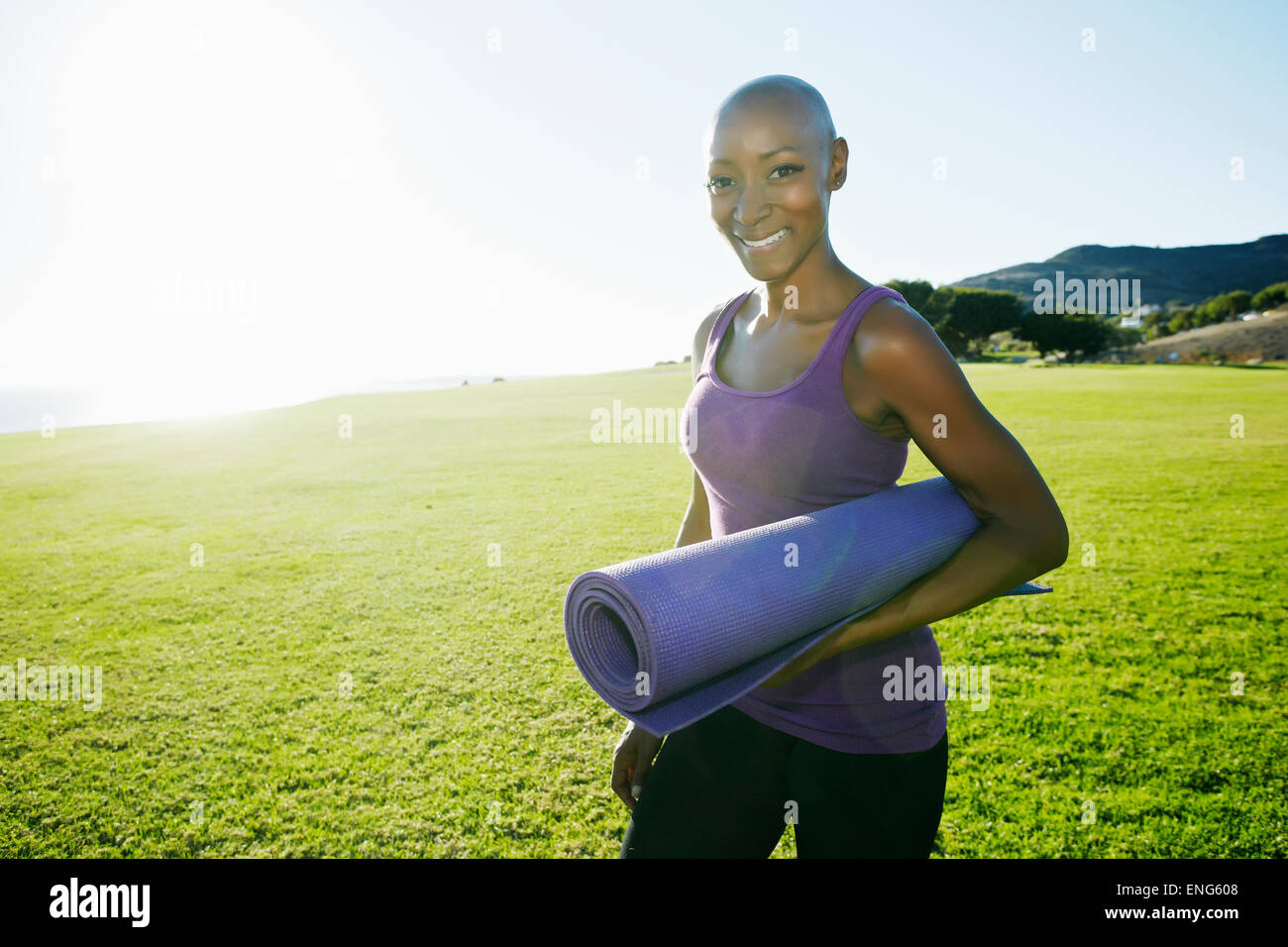 African American Woman carrying yoga mat in park Banque D'Images