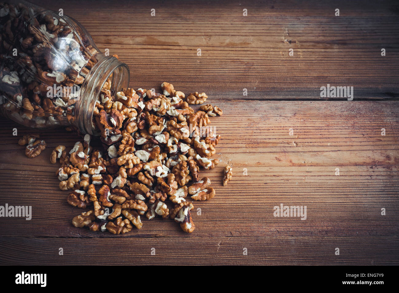 Les cerneaux de noix et les noix entières sur table en bois rustique vieux pot en verre Banque D'Images