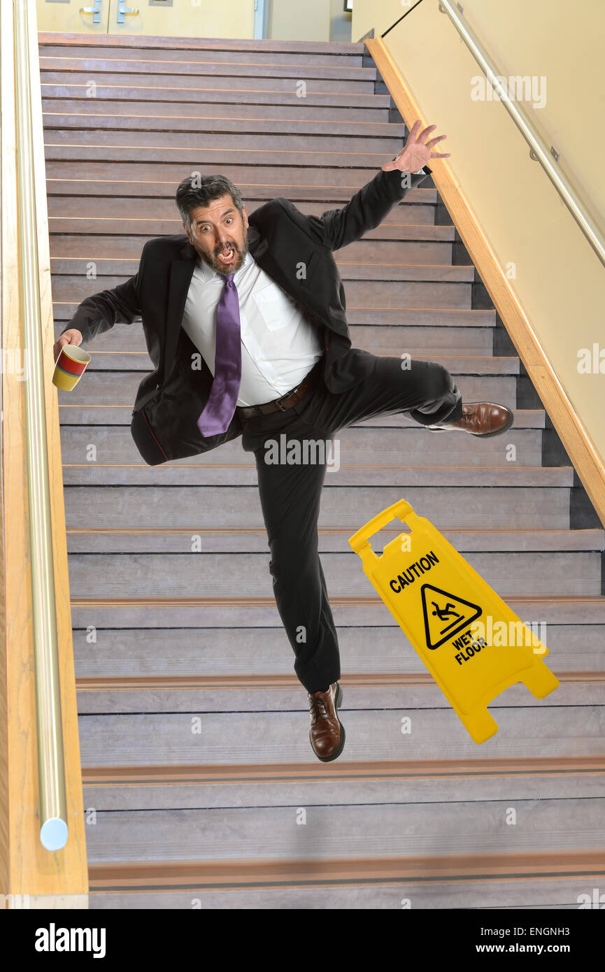 Young Hispanic businessman de tomber dans les escaliers Photo Stock