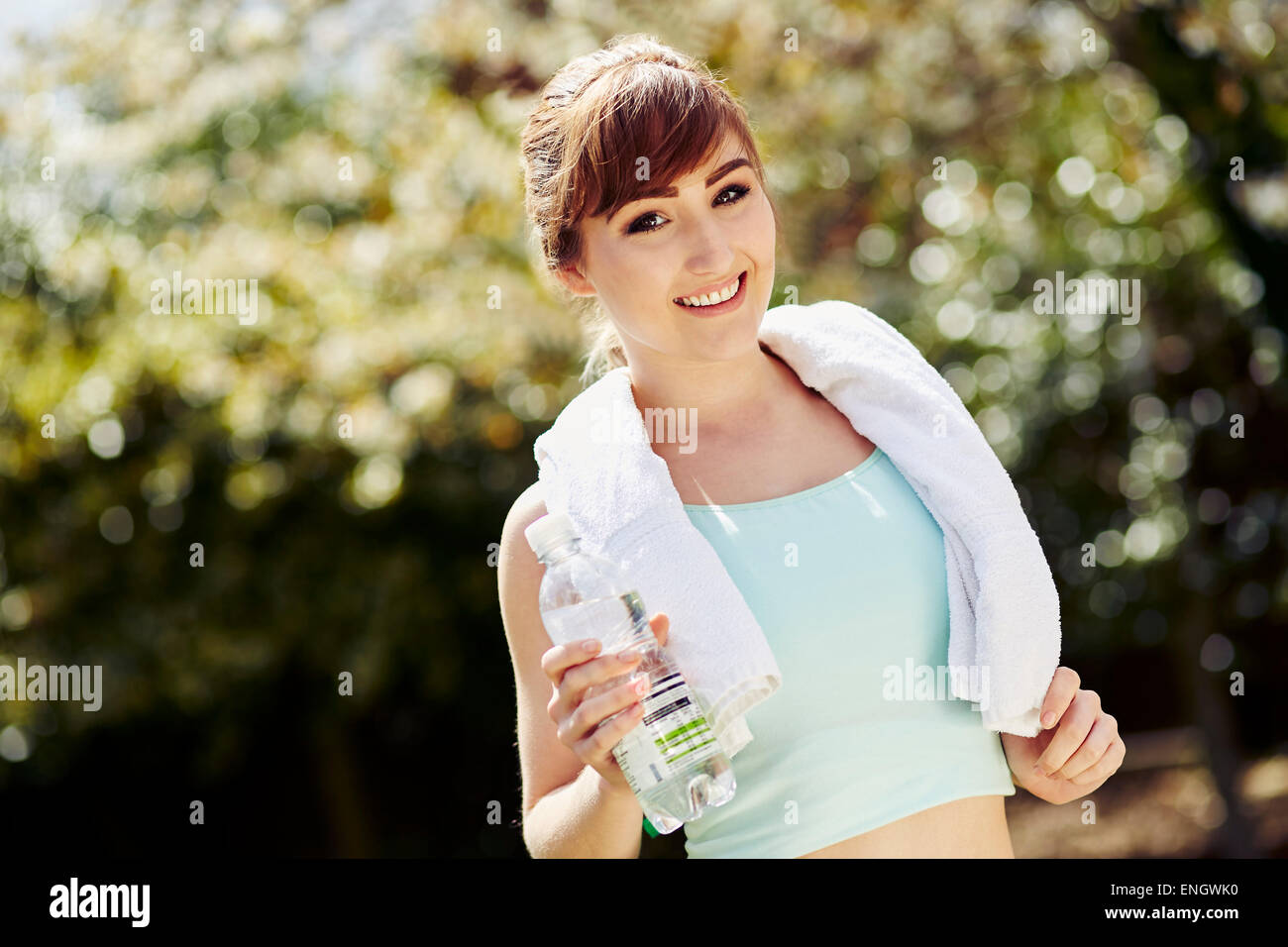 Belle jeune fille tenant une bouteille d'eau après l'entraînement Banque D'Images