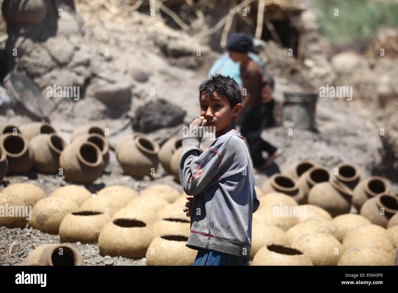 Fayoum, Egypte. 4 mai, 2015. Un garçon égyptien se trouve à côté de la poterie produits à un atelier dans le village de Nazla, Fayoum, à environ 130 kilomètres au sud-ouest, à Le Caire, Égypte, le 4 mai 2015. Le village de Nazla est l'un des trois sites de production de céramique dans la région de Fayoum, et en 2006 il a été inclus dans le Fayoum Site de l'écotourisme en raison de son naturel, l'environnement et son importance géologique. Cependant, le nombre de touristes a diminué considérablement depuis 2011, qui a affecté le revenu des travailleurs locaux, selon les propriétaires de l'atelier. © Ahmed Gomaa/Xinhua/Alamy Live News Banque D'Images