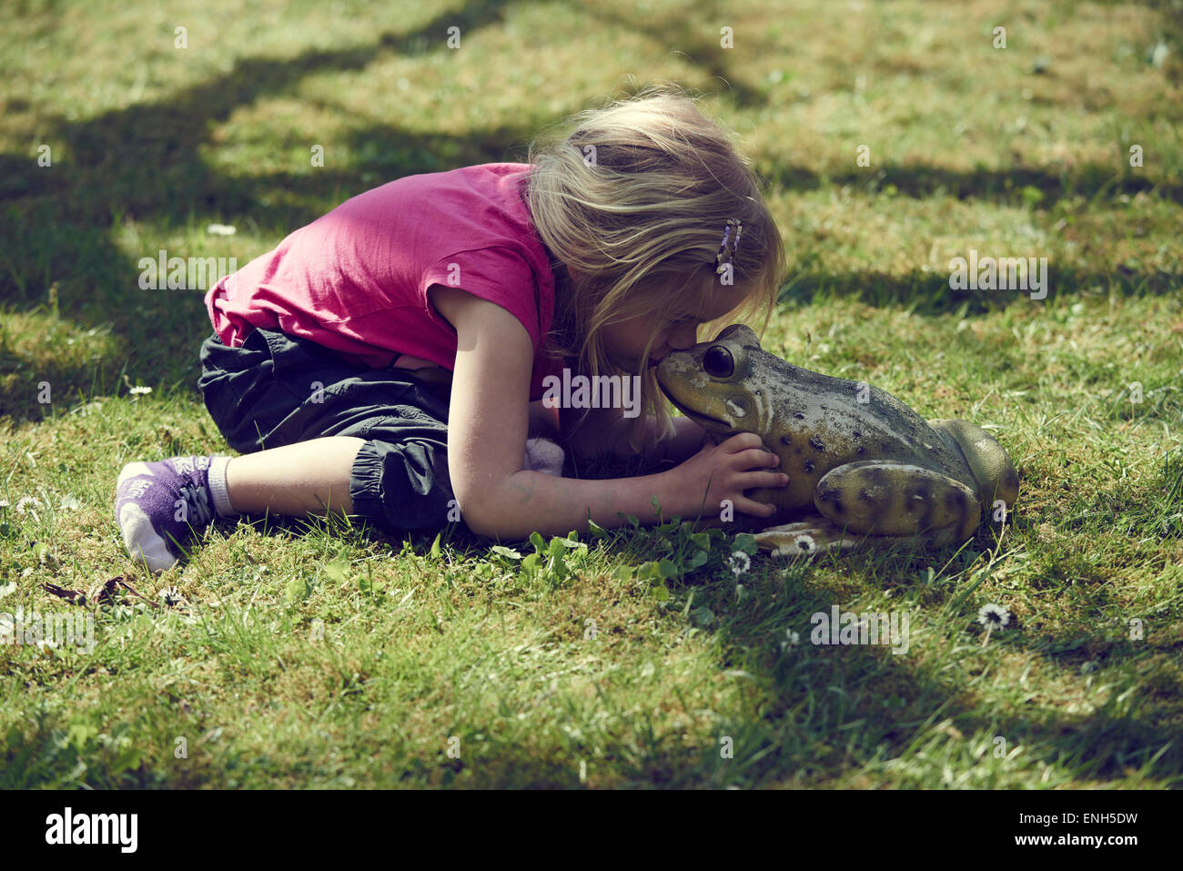 Petite blonde girl kissing Roi Grenouille enchantée Banque D'Images