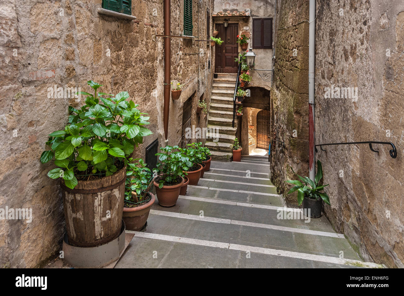 Ascendant et descendant les escaliers en brique avec des plantes en pot à Pitigliano, Province de Grosseto, Italie Banque D'Images