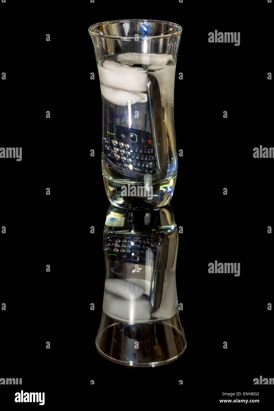 Smart phone jeté dans un verre d'eau glacée Banque D'Images