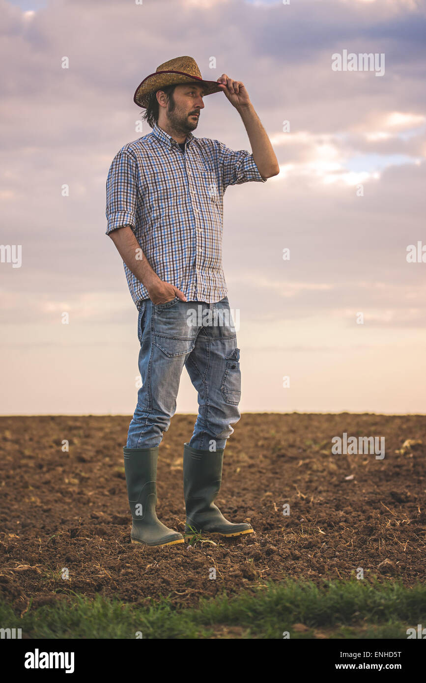 Portrait d'homme adulte fermier sur les terres agricoles fertiles sur le sol,à la recherche dans la distance. Banque D'Images