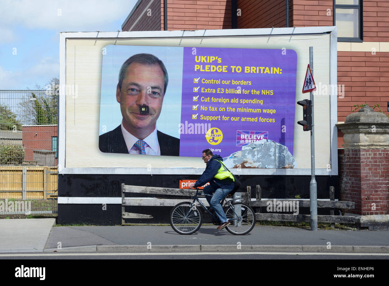 Sur un parti pour l'indépendance du Royaume-Uni, 2015 affiche électorale une moustache noire a été attirée sur la photo de la chef de l'UKIP Nigel Farage à Portsmouth, Royaume-Uni.​ Banque D'Images