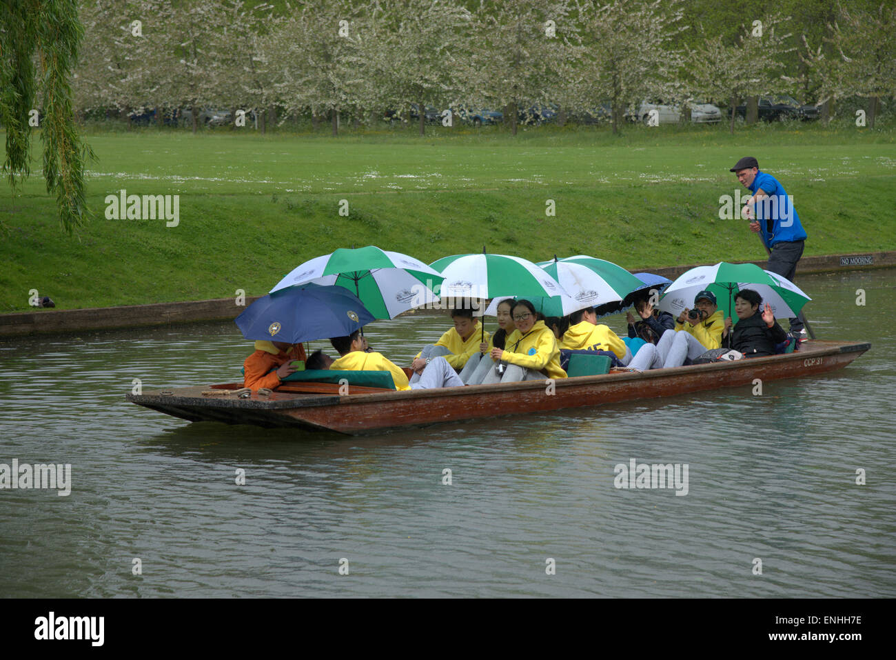 Cambridge, UK. 6 mai, 2015. Météo britannique. Les touristes sont pris dans une douche et à l'abri sous des parasols colorés tout en barque sur la rivière Cam à Cambridge UK. La prévision est d'un jour venteux avec alternance de soleil et de douches pour la région du Sud Est. Julian crédit Eales/ Alamy Live News Banque D'Images