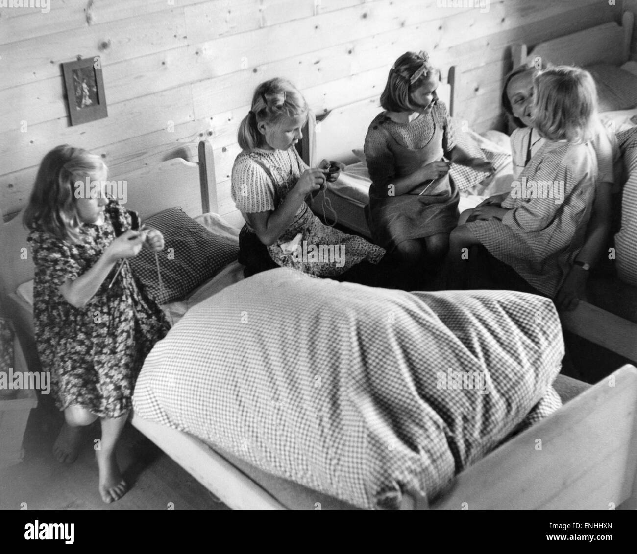 Polish girls knitting avec leur maison-mère. Ces enfants ont été déportés de la Pologne à l'Allemagne par les Nazis en raison de leur apparence aryenne ; on leur a donné l'allemand les parents d'accueil, qui ont été chargés de les transformer en allemands nazis. Ils parlent les deux P Banque D'Images