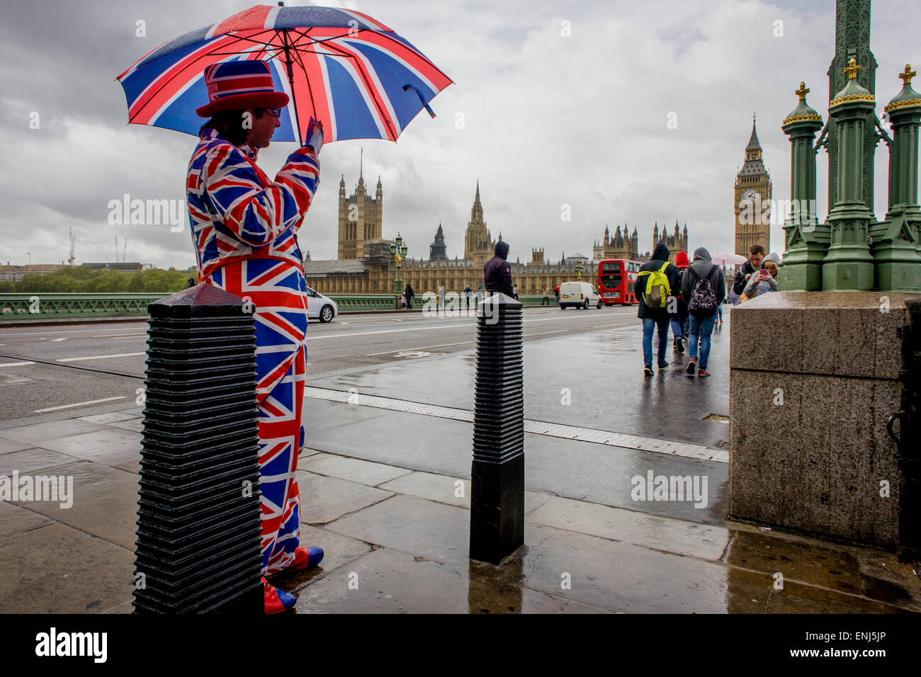 Des vents forts et les conditions météorologiques humides herald une semaine d'incertitude dans la Bretagne à moins de 24 heures avant l'élection générale. Peu probable que les perspectives d'un gouvernement majoritaire à la fin de la semaine, les offres d'orageuses entre les partis et le mécontentement des électeurs. Un dépliant touristique homme habillé en union jacks donne des détails d'un poisson et à proximité d'affaires à puce, en face du Palais de Westminster de Westminster Bridge. Banque D'Images