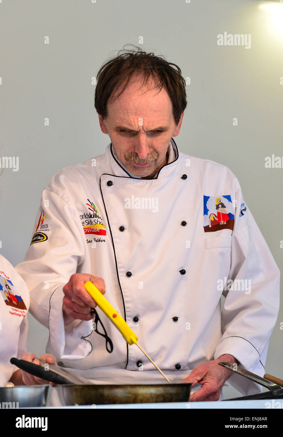 Chef cuisinier avec pliage numérique Thermomètre à sonde pour vérifier la température d'aliments chauds à démonstration culinaire à Londonderry Banque D'Images