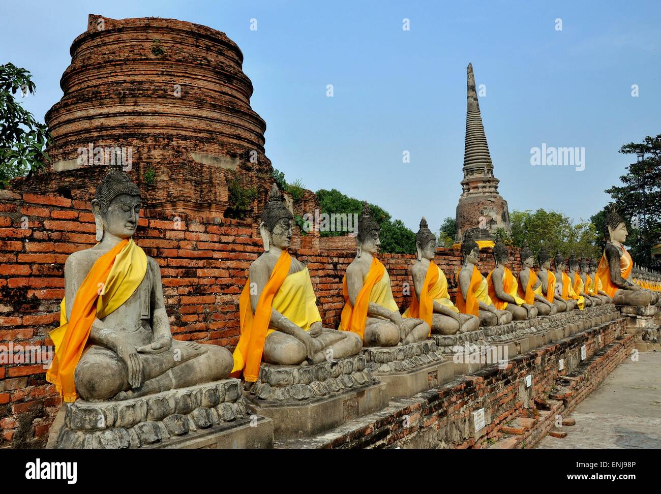 Ayutthaya, Thaïlande : cloître de Bouddha avec des rangées de bouddhas  assis vêtu de couleur orange safran et écharpes en soie Photo Stock - Alamy