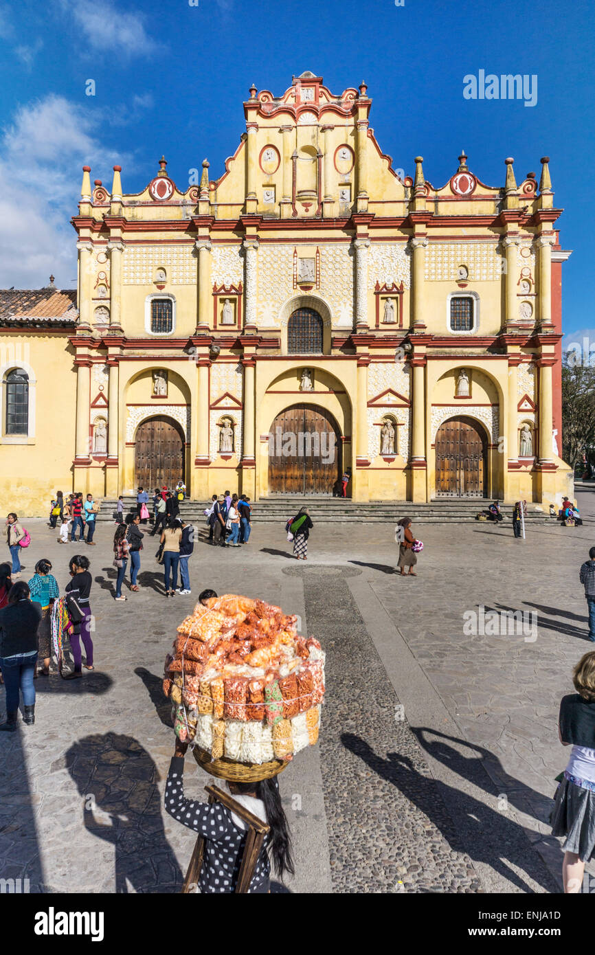 Vendeur porte énorme paquet de traite sur la Plaza de San Cristobal en face de façade mauresque de couleur vive de cathédrale de la ville Banque D'Images