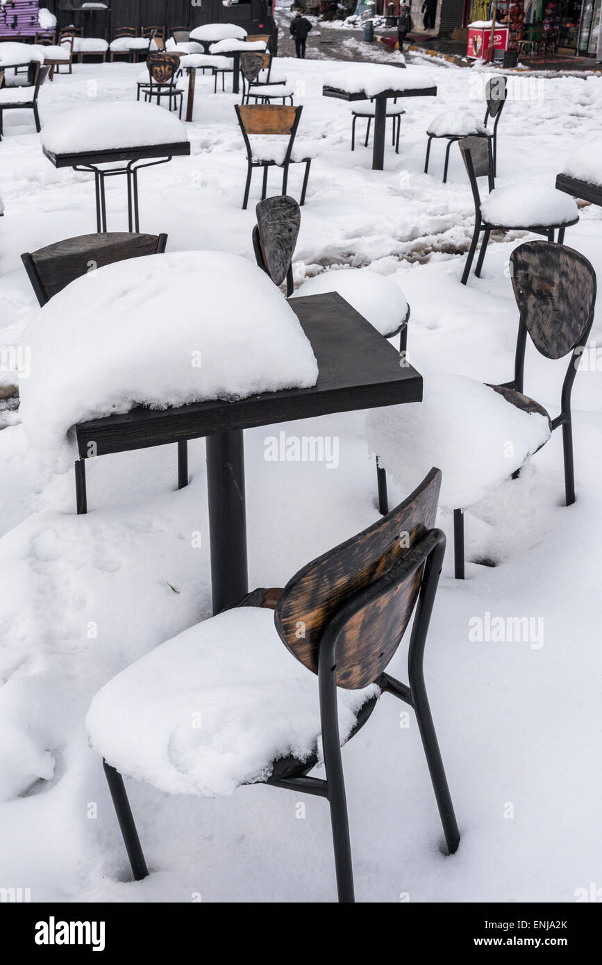 La neige et la glace couvrant cafe chaises et tables à Karakoy, Istanbul, Turquie. Banque D'Images