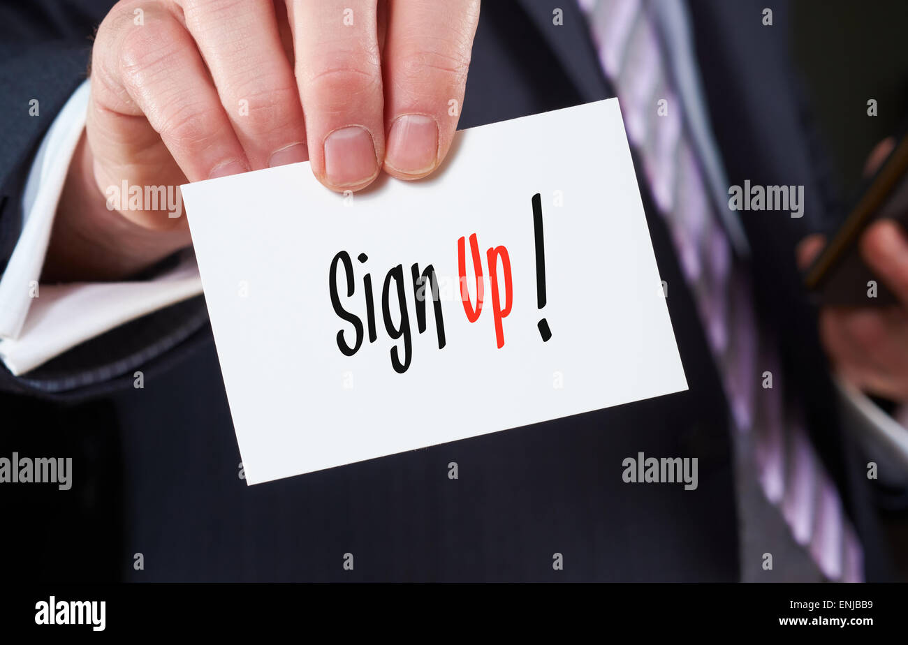 Un homme tenant une carte d'affaires avec les mots, s'enregistrer, d'inscrit. Banque D'Images