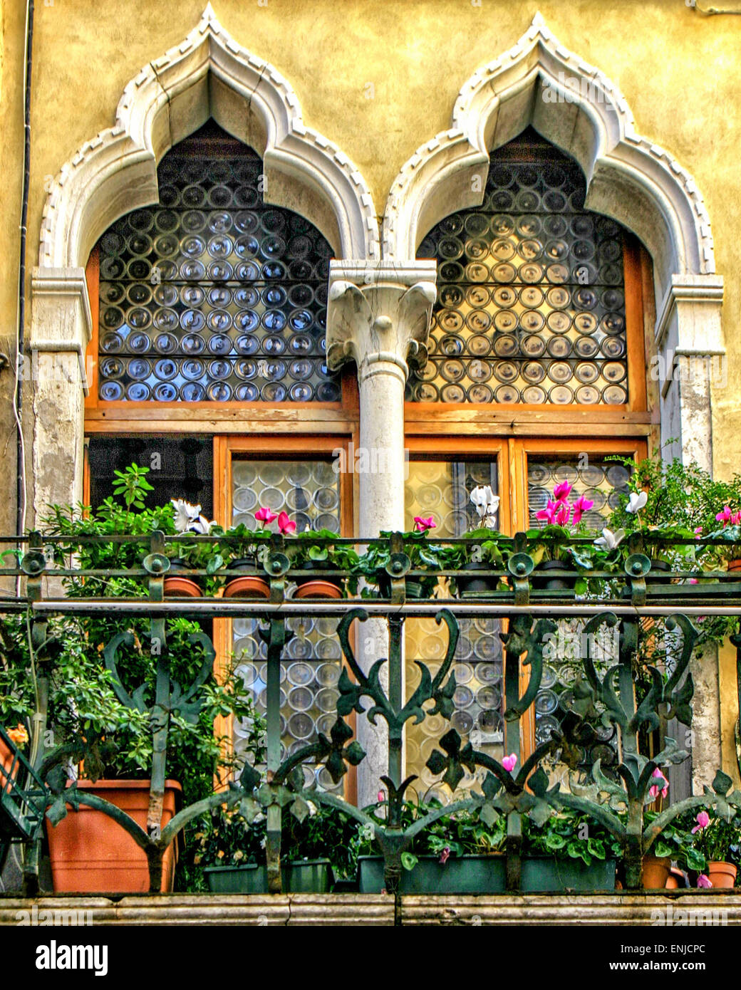 Venise, Province de Venise, Italie. 6Th Oct, 2004. Une paire de fenêtres de style gothique vénitien avec des influences byzantines et de l'architecture mauresque, décorées de fleurs sur le balcon en fer forgé. Venise, Site du patrimoine mondial de l'UNESCO, est l'un des plus populaires destinations touristiques internationales © Arnold Drapkin/ZUMA/Alamy Fil Live News Banque D'Images
