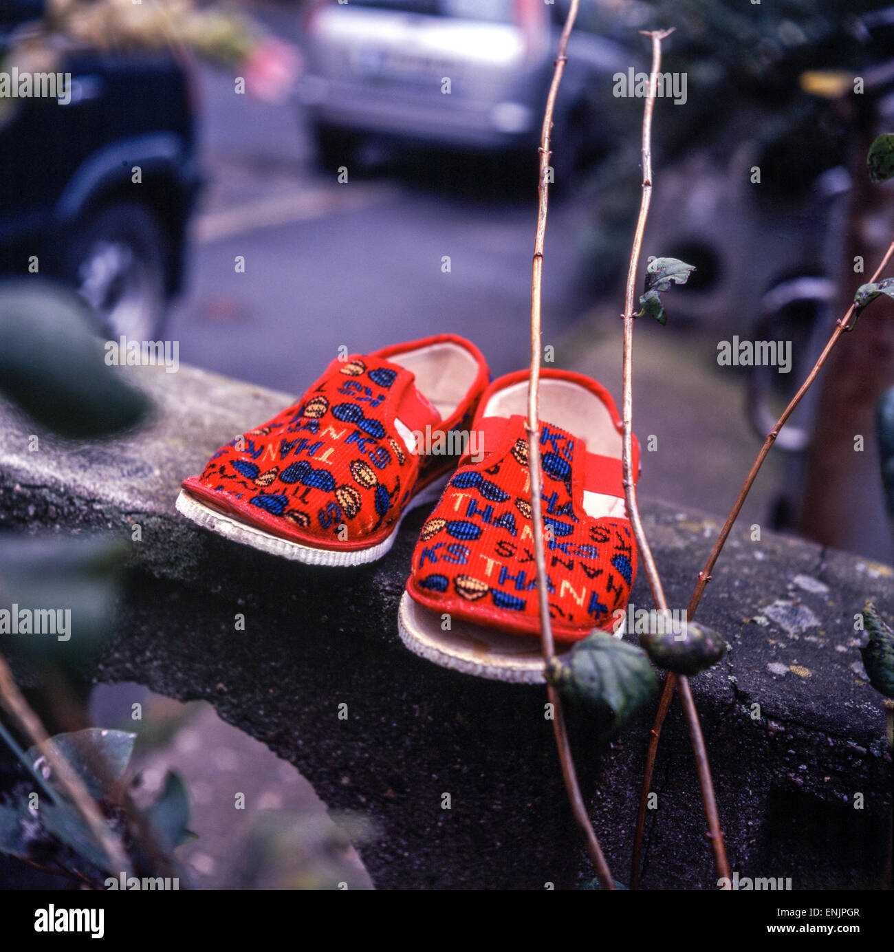Chaussures usées chaussons rouges jetés pour enfants Banque D'Images