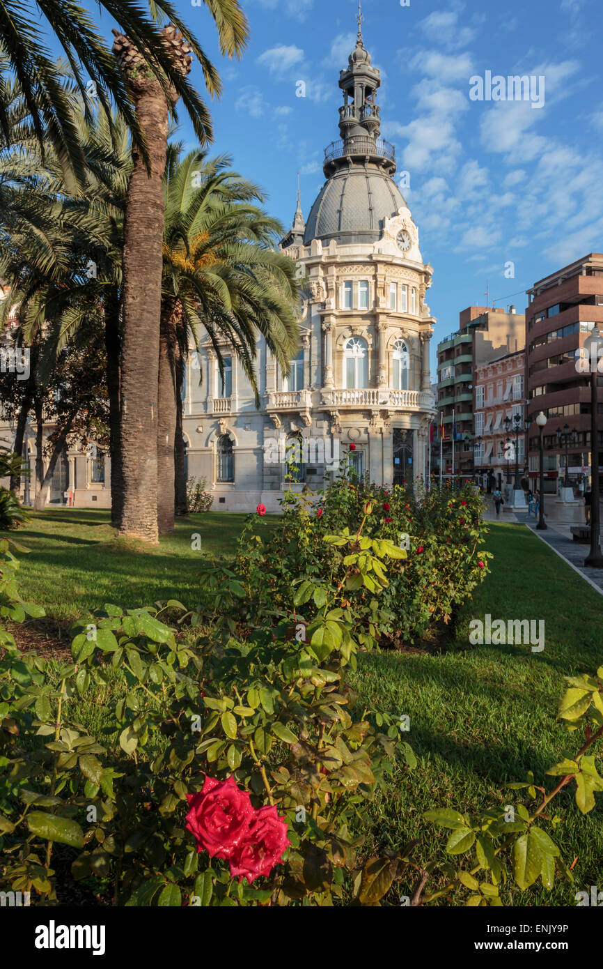 L'Hôtel de ville sous un nuage ciel bleu pommelé avec palmiers et de roses, Carthagène, Région de Murcie, Espagne, Europe Banque D'Images