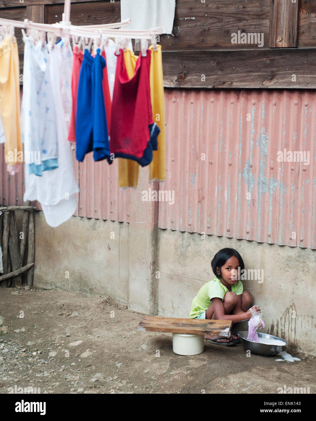 Laver les vêtements de fille dans le petit village de Philippines. Environ 12 pour cent des Philippines Banque D'Images