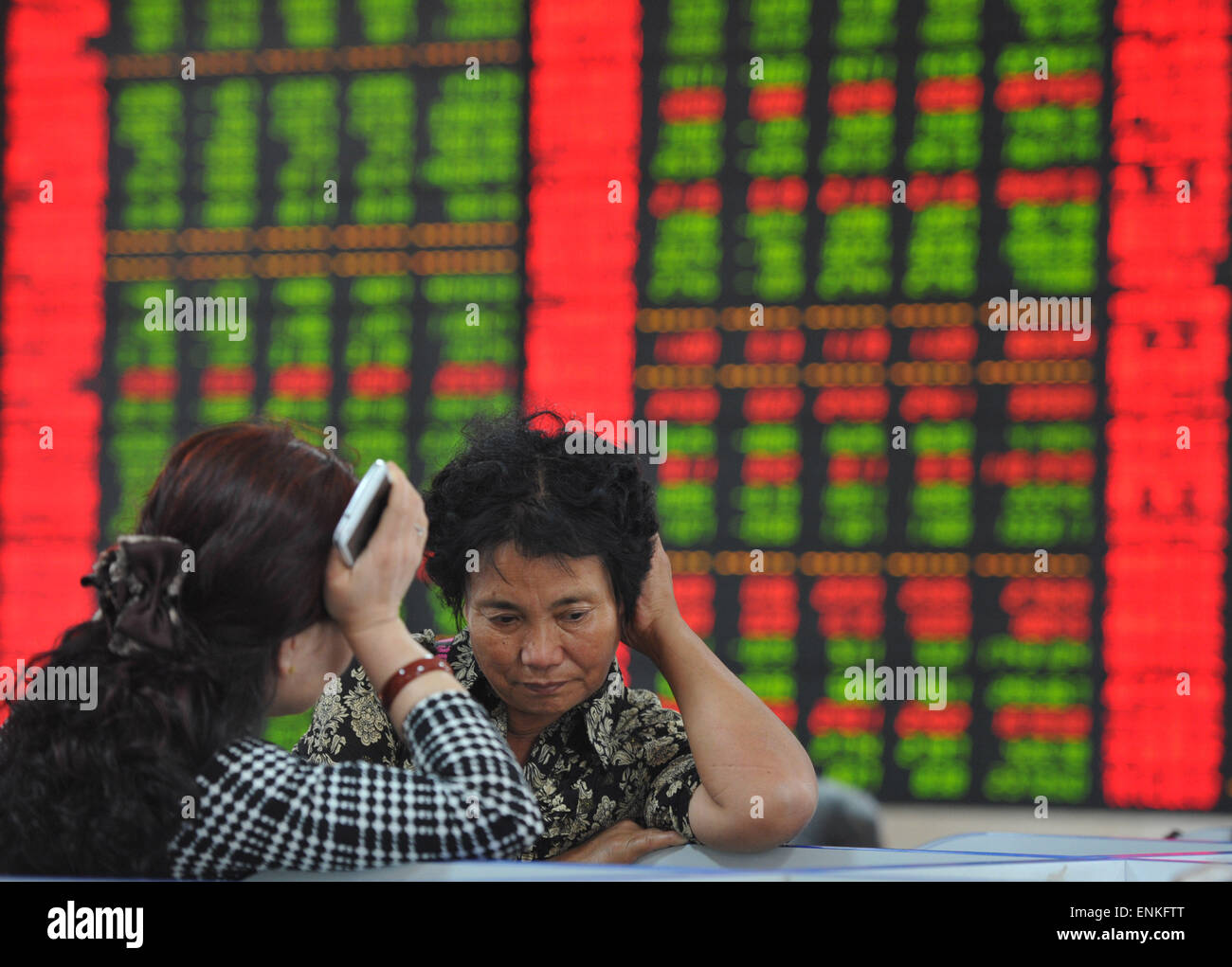 Fuyang. 7 mai, 2015. Suivez les investisseurs information à un stock trading hall à Fuyang, Chine de l'est l'Anhui Province, le 7 mai 2015. La baisse prolongée des actions chinoises le jeudi, l'enregistrement de plus de 8 pour cent de pertes par le passé trois jours de négociation. L'indice Shanghai Composite Index a chuté 2,77  % pour finir à 4 112,21 points. La composante de Shenzhen a chuté de 0,15 pour cent pour clôturer à 14 114,73 points. © Xinhua/Alamy Live News Banque D'Images