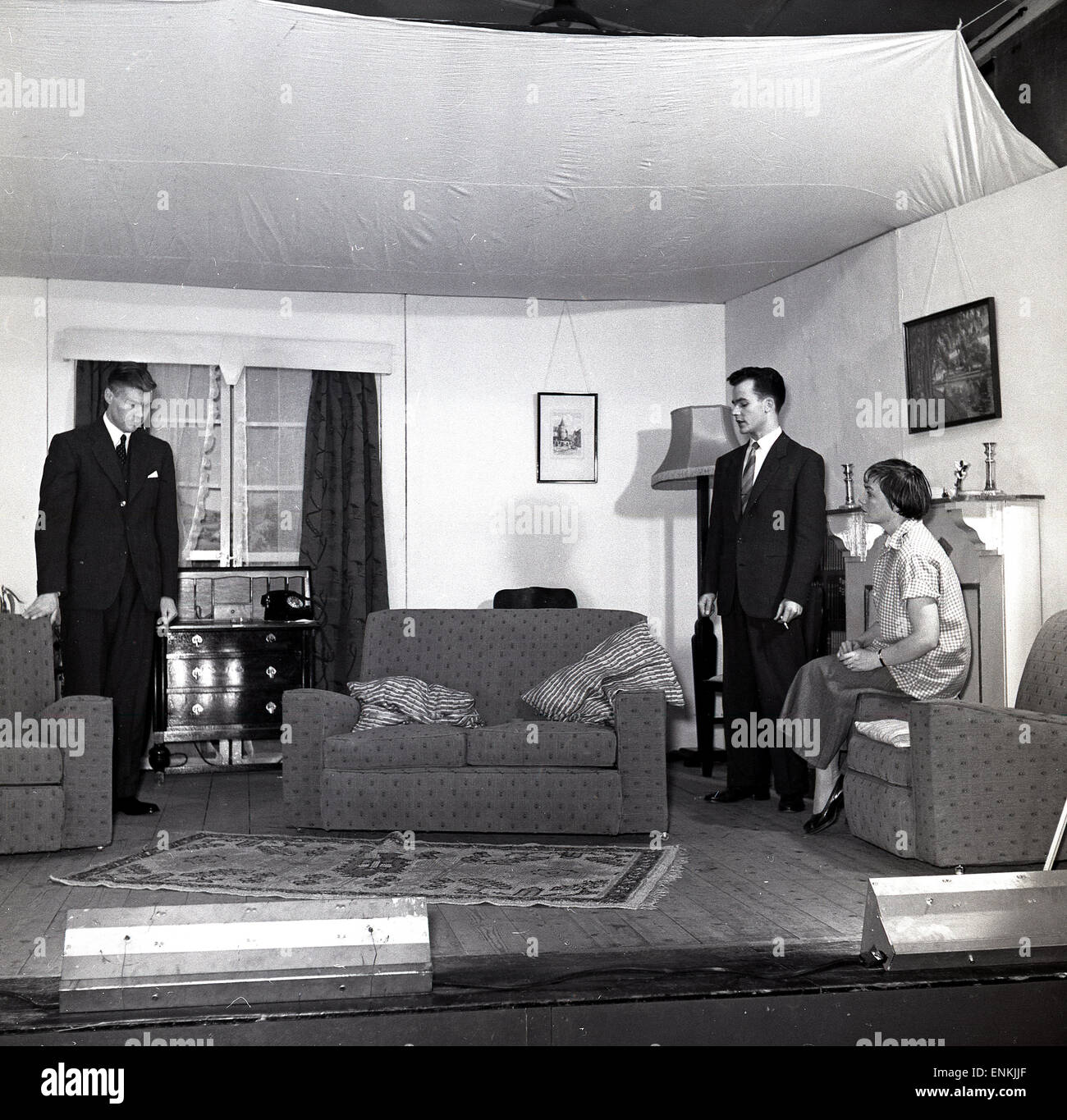 Historique, 1950, dramatics amateurs, trois acteurs, deux hommes et femmes sur scène agissant dans un ensemble d'un salon dans une maison, Angleterre, Royaume-Uni. Dans les jours qui ont précédé la télévision, le théâtre amateur était une activité populaire dans les communautés, en particulier pour ses aspects sociaux. Banque D'Images