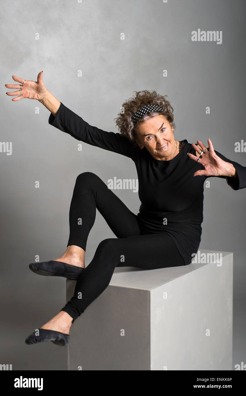 Portrait de studio de 83 à la bonne vieille femme gymnaste senior blanc sur fond gris, l'exercice de Banque D'Images