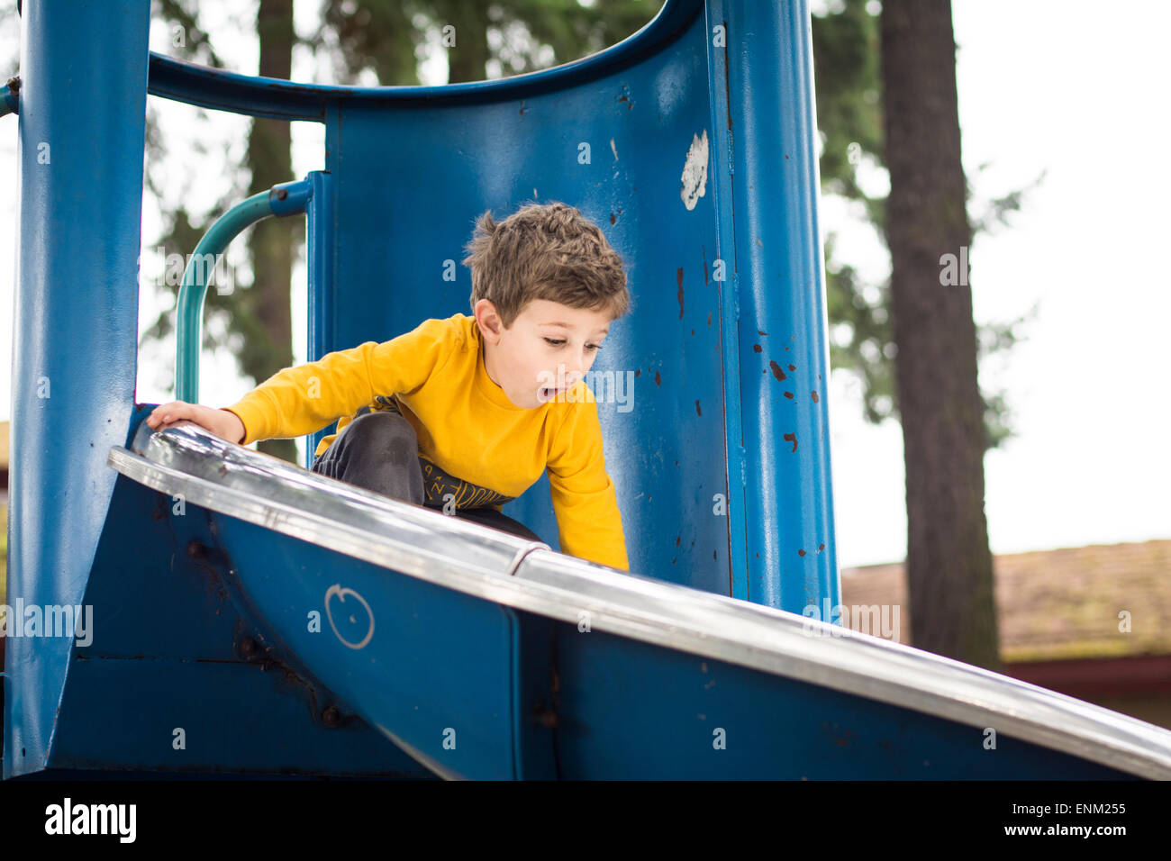 Bébé garçon anticipe une dégringolade dans l'aire de jeux, Portland, Oregon. Banque D'Images