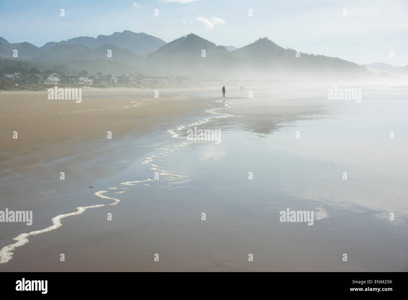 Silhouette adultes explore les rivages brumeux de Cannon Beach, Oregon. Banque D'Images