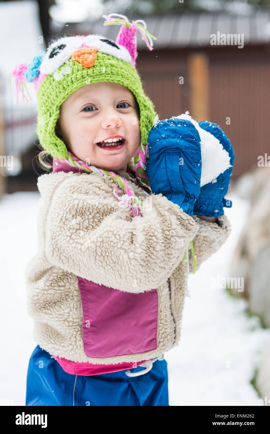 Smiling girl s'apprête à lancer snowball vers la caméra, Lake Tahoe, en Californie. Banque D'Images