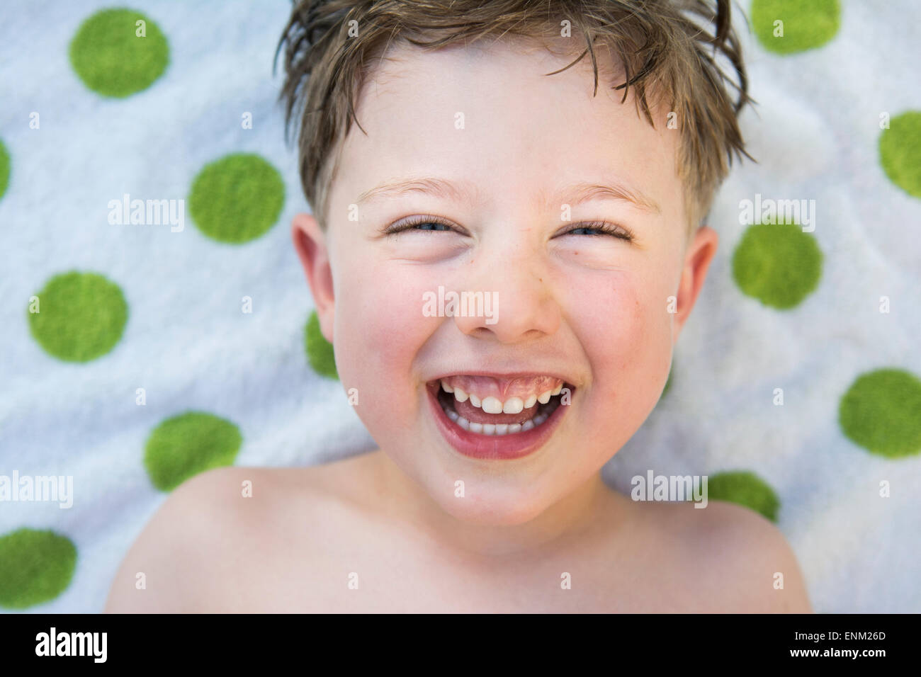 Close-up of toddler boy's smiling face avec green poca-serviette en pointillé dans l'arrière-plan Chico, Californie. Banque D'Images