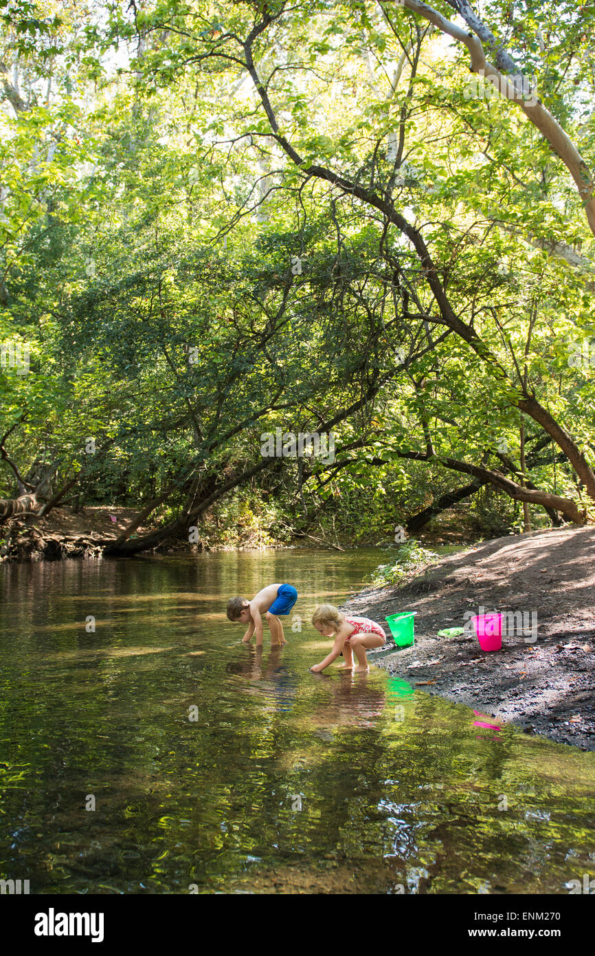 Bébé garçon et fille recherche de roches dans creek à Bidwell Park, Chico, Californie. Banque D'Images