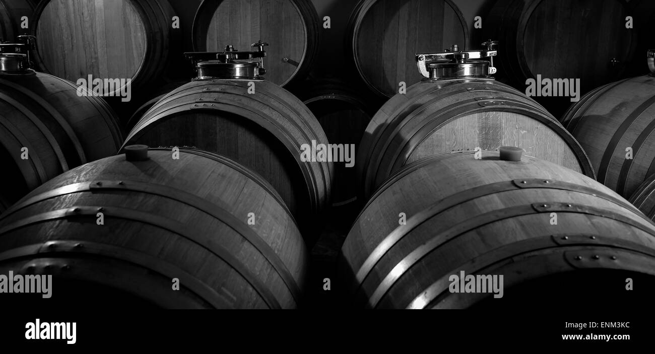 Des tonneaux de vin empilées dans cave, vignoble de Bordeaux, France Banque D'Images
