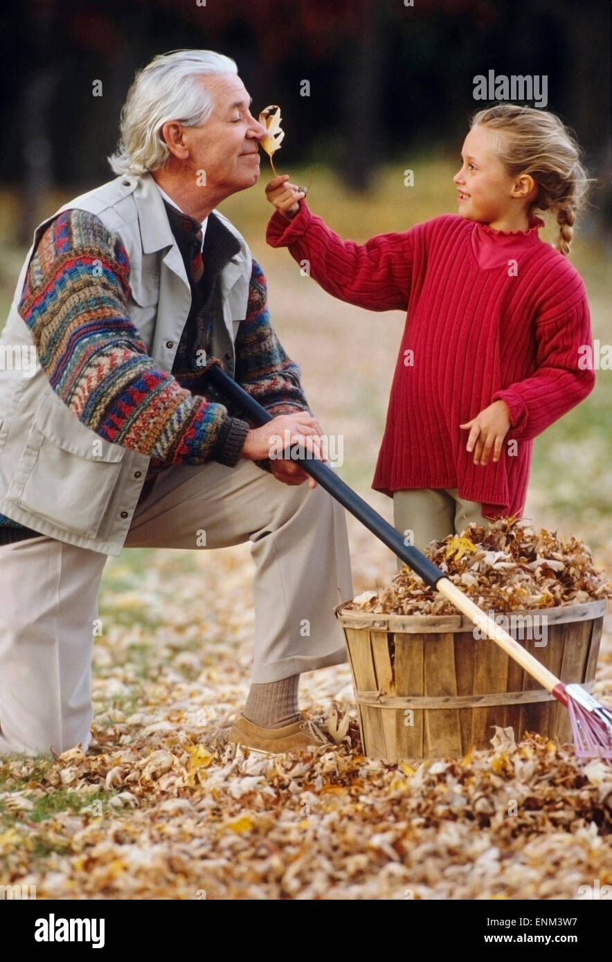 Grand-père et sa petite-fille avec des feuilles Banque D'Images