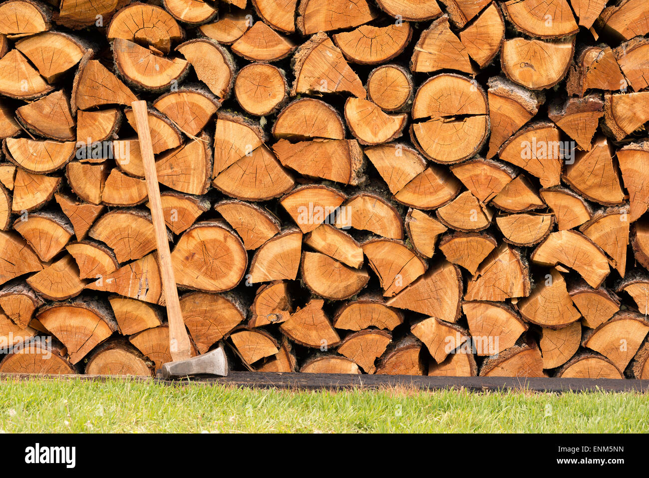 Hache à fendre et parfaitement empilées pile de bois de chauffage fendu. Banque D'Images