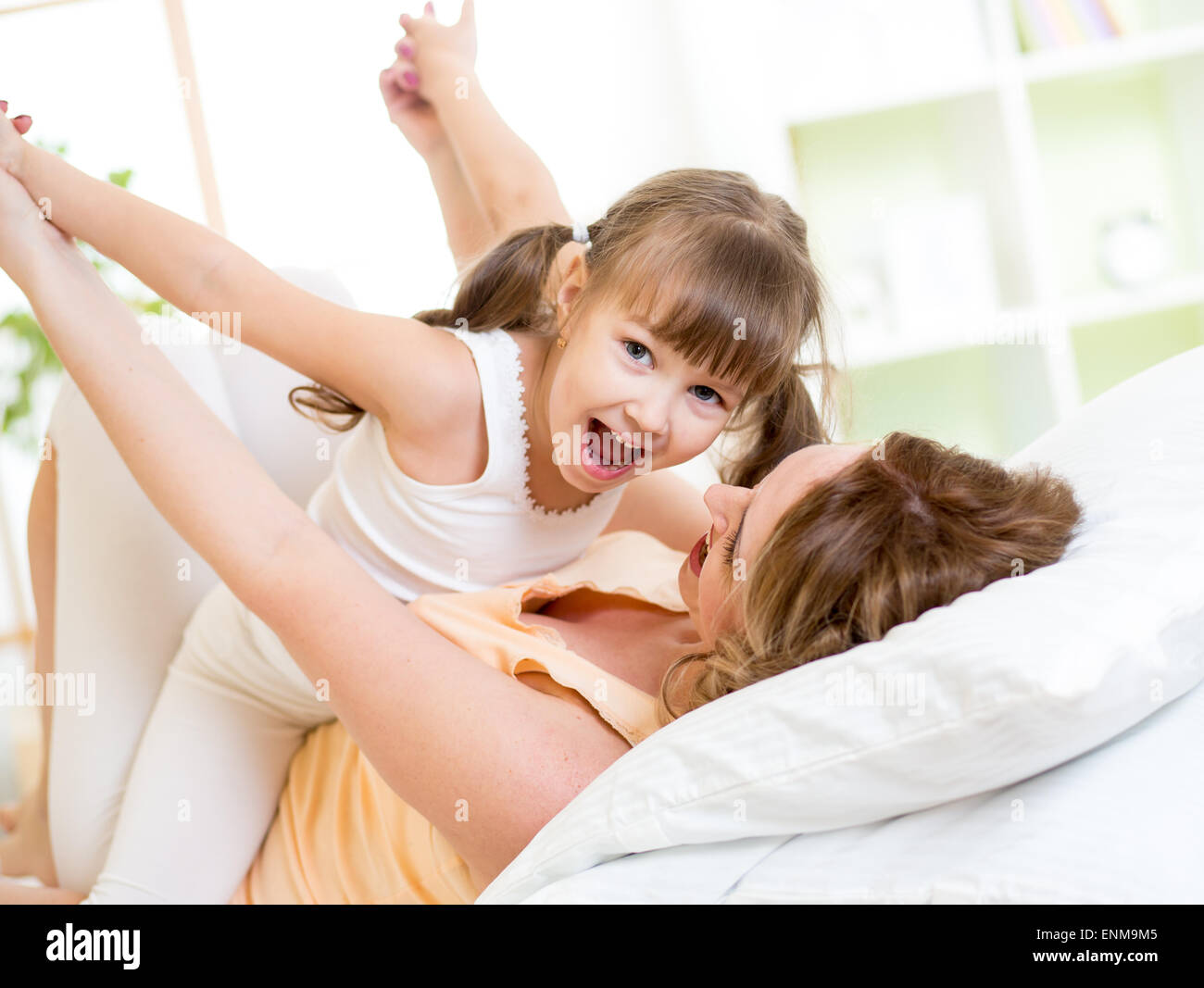 Happy mother and child girl in bedroom Banque D'Images